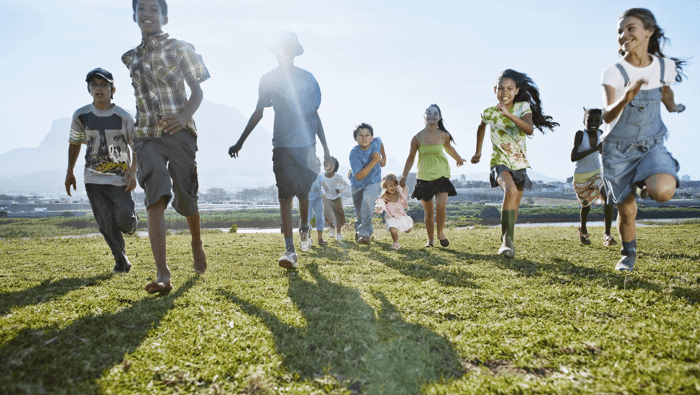 niños corriendo por una pradera