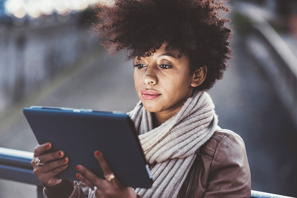 Young woman browsing on tablet outdoors