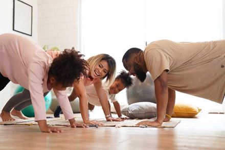 Family cheerful laughing exercise together at room