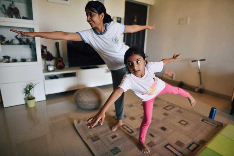 Mom and daughter doing a yoga balance pose