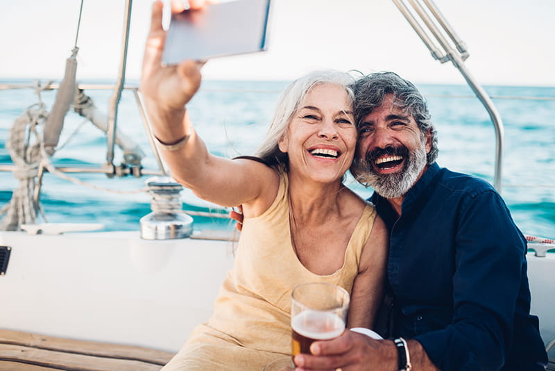 pareja feliz sobre un velero tomándose un selfi