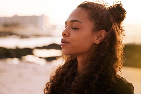 Close-up of young woman with eyes closed, feeling the sunshine