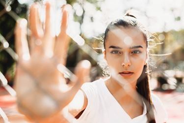 Mujeres jóvenes sosteniendo la mano contra una valla de cadena