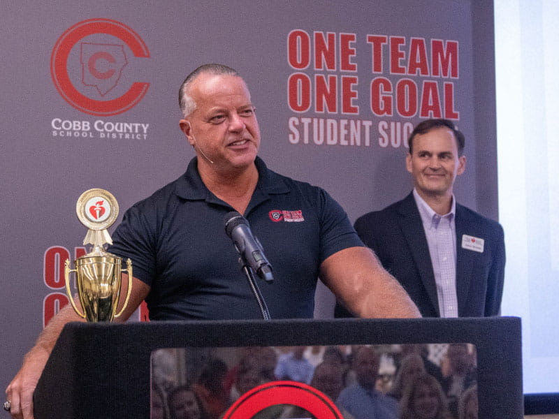 Superintendent Chris Ragsdale accepts Cobb County School District's 2021-22 trophy as the top fundraiser nationwide in the American Heart Association's school heart challenges. This school year, the district repeated the feat – and set an all-time fundraising record. (Photo courtesy of Cobb County schools)