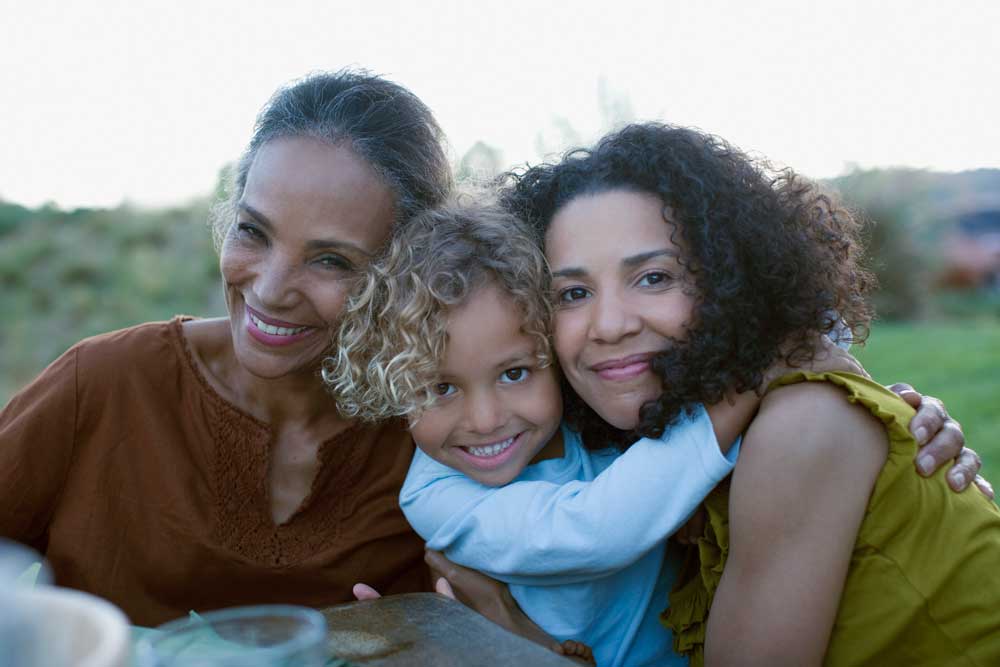 Madre y abuela abrazando a un niño