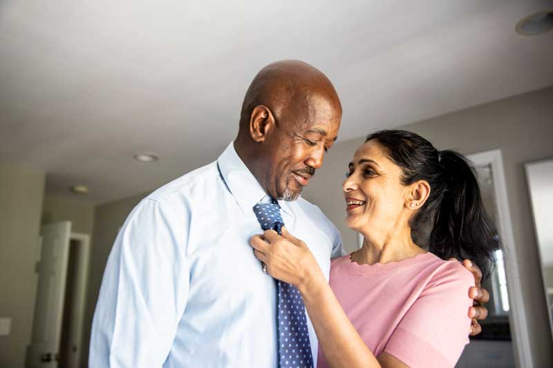 esposa acomodando la corbata de su esposo