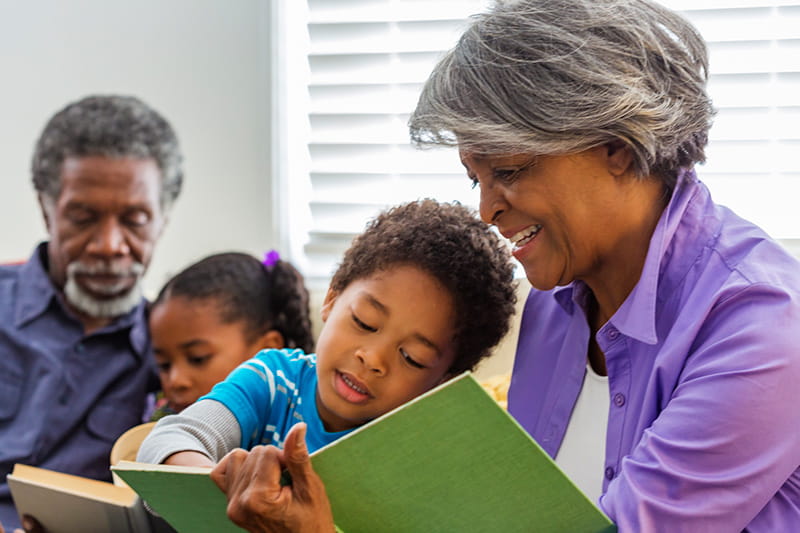 grandparents reading books to grandchildren