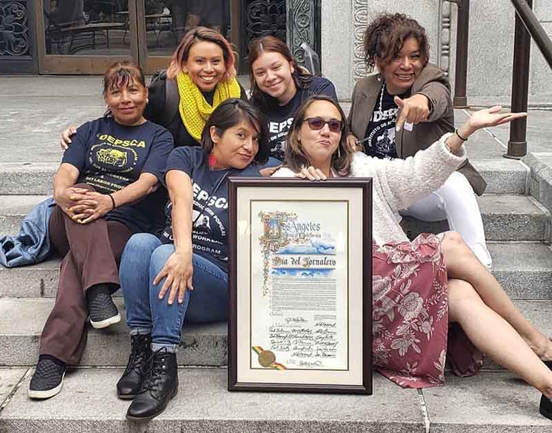 María de Lourdes Alvarado (at right, in white pants) joins in celebrating a Los Angeles proclamation last year, marking Día del Jornalero, Day of the Day Laborer. Alvarado, who is holding down two jobs, is helping educate her community after her recovery from COVID-19. (Photo courtesy of María de Lourdes Alvarado)