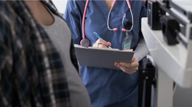 Nurse weighing pregnant woman