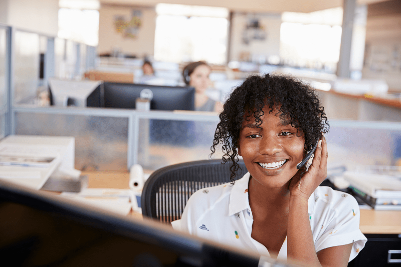 mujer trabajando en un centro de atención telefónica contestando el teléfono