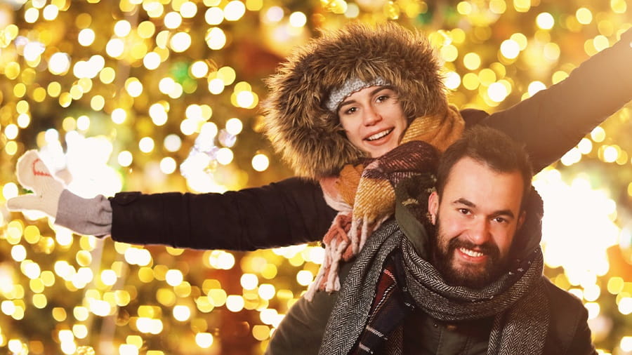 Man and woman in front of Christmas Tree