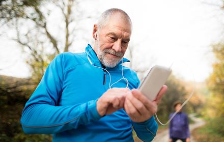 senior runner using headphones choosing song senior runner using headphones choosing song