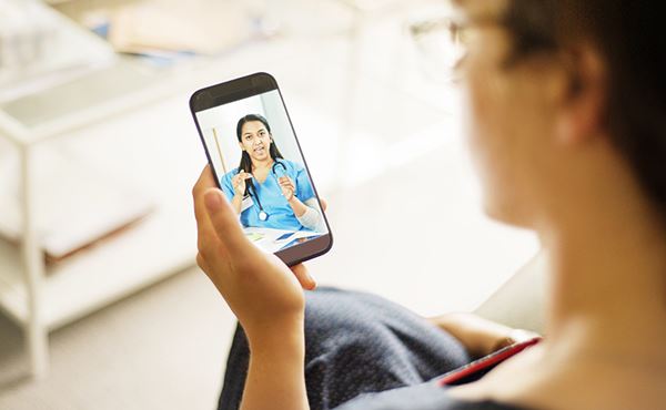 woman has virtual doctor's appointment on phone woman has virtual doctor's appointment on phone