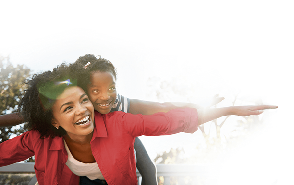 mother giving daughter ride on her back pretending to fly
