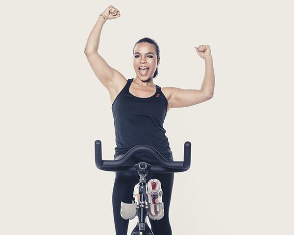 Candy Calderon using an exercise bike and cheering Candy Calderon using an exercise bike and cheering