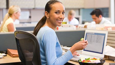 business woman eating lunch at her desk while working business woman eating lunch at her desk while working