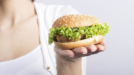 close up of chicken sandwich on a woman's hand close up of chicken sandwich on a woman's hand