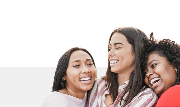 Three happy young multi-ethnic women embracing