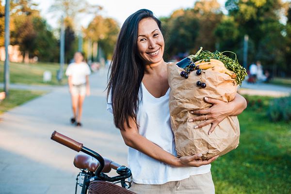middle-aged woman carrying grocery bad on bike middle-aged woman carrying grocery bad on bike
