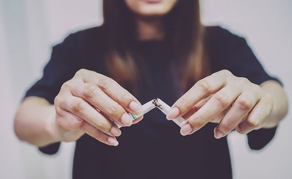 woman breaking a cigarette in half