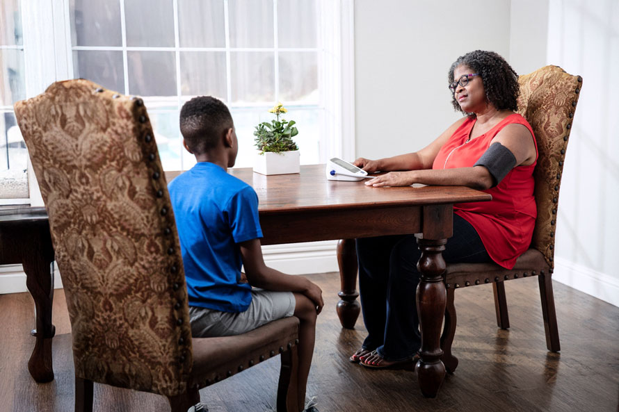 Woman checking her blood pressure at home