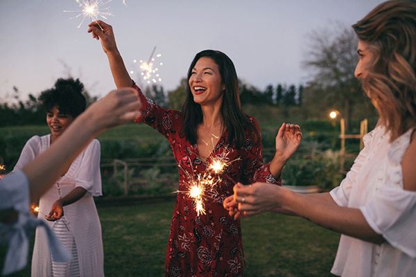 happy frirends playing with sparklers outdoors happy friends playing with sparklers outdoors