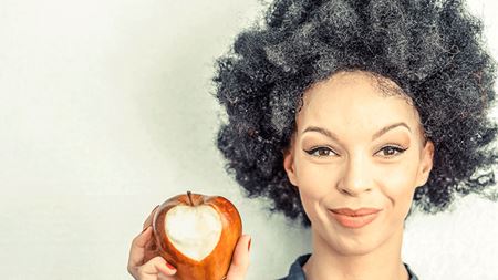 gray-haired woman eating apple with heart shape bite gray-haired woman eating apple with heart shape bite