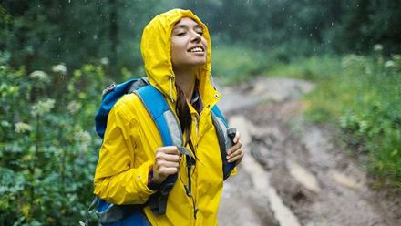 Young woman in raincoat enjoys nature in the rain Young woman in raincoat enjoys nature in the rain