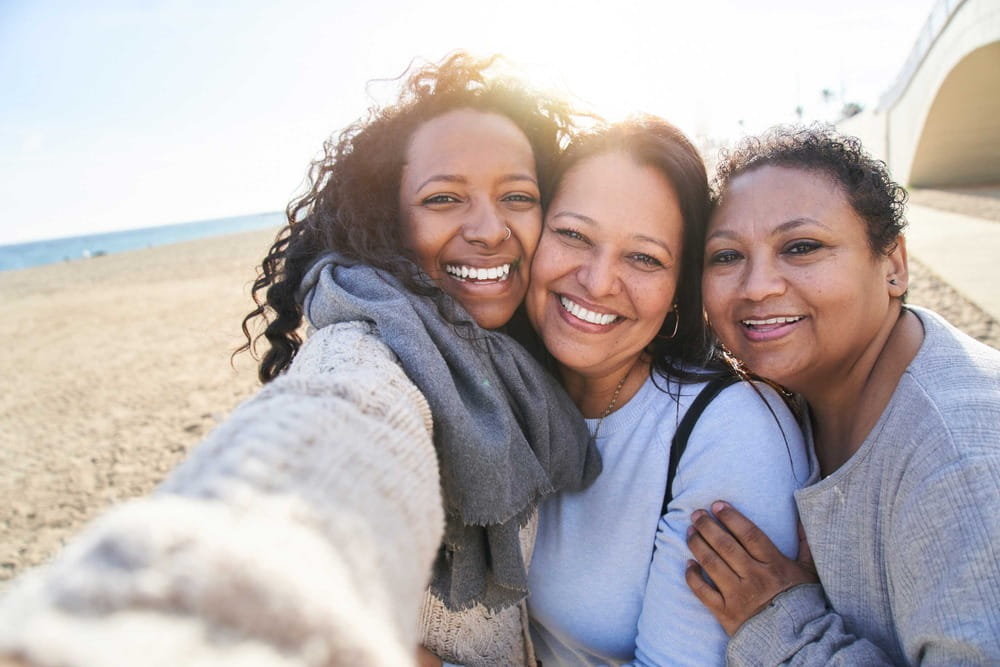 Three happy women taking selfie.